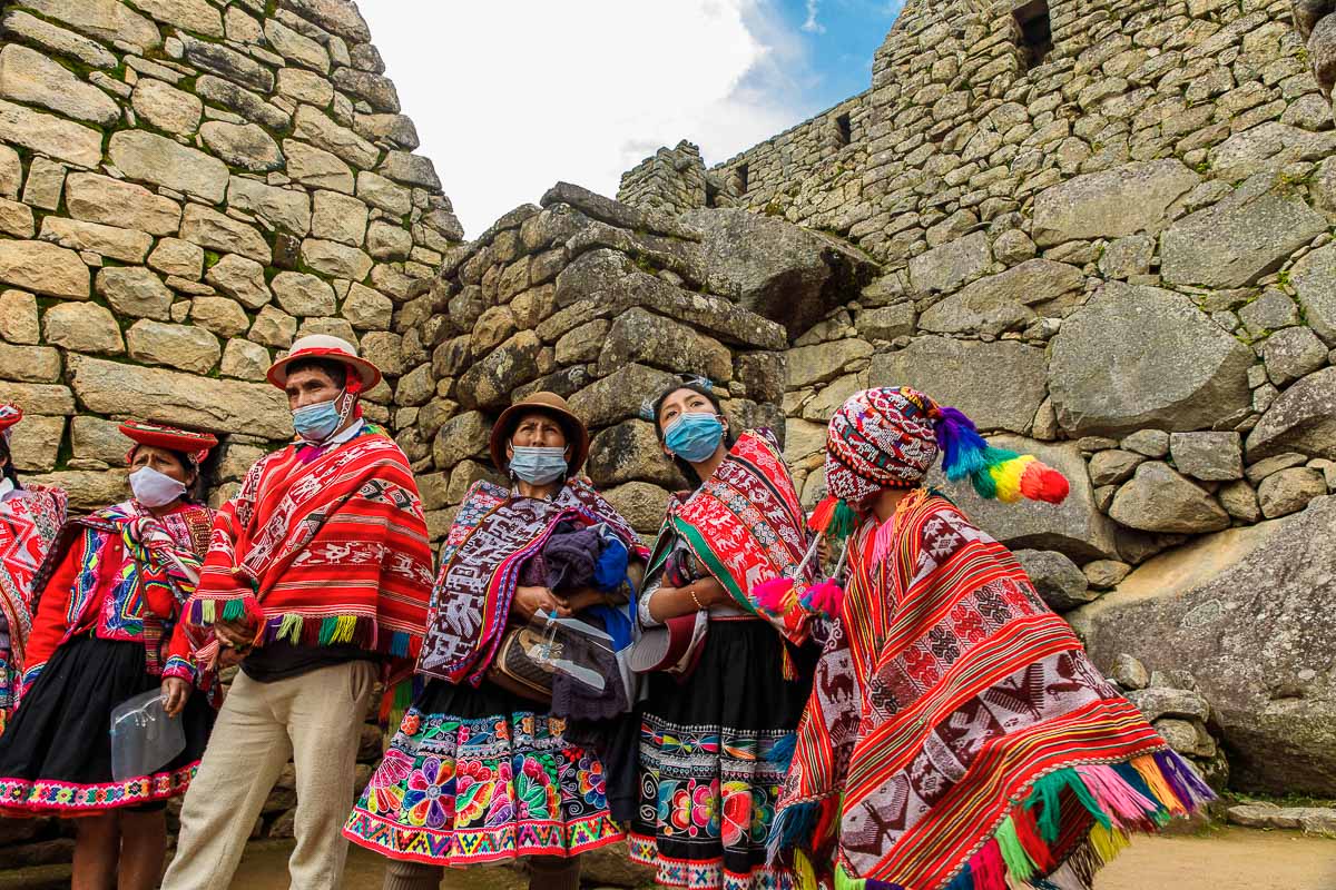 A boy and his parents taking photos at the main entrance to Machu Picchu.