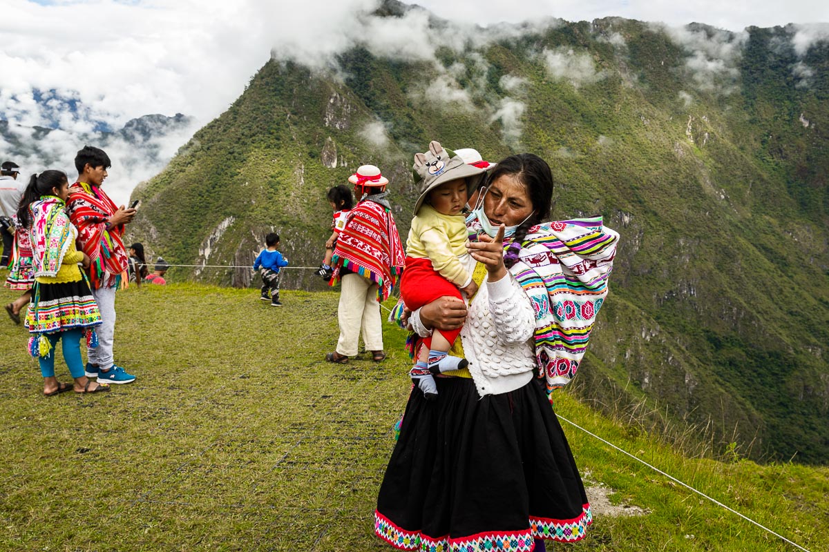 A Quechua mother tells her son to smile for a photo at Machu Picchu