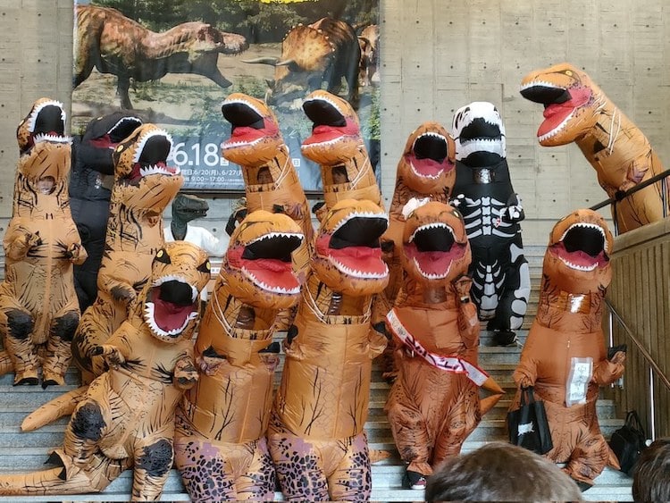 T-Rex Exhibition With Attendees Wearing Dinosaur Costumes