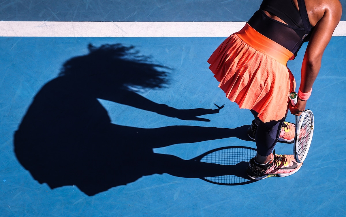 Japan's Naomi Osaka removes a butterfly from her dress as she plays against Tunisia's Ons Jabeur at the Australian Open