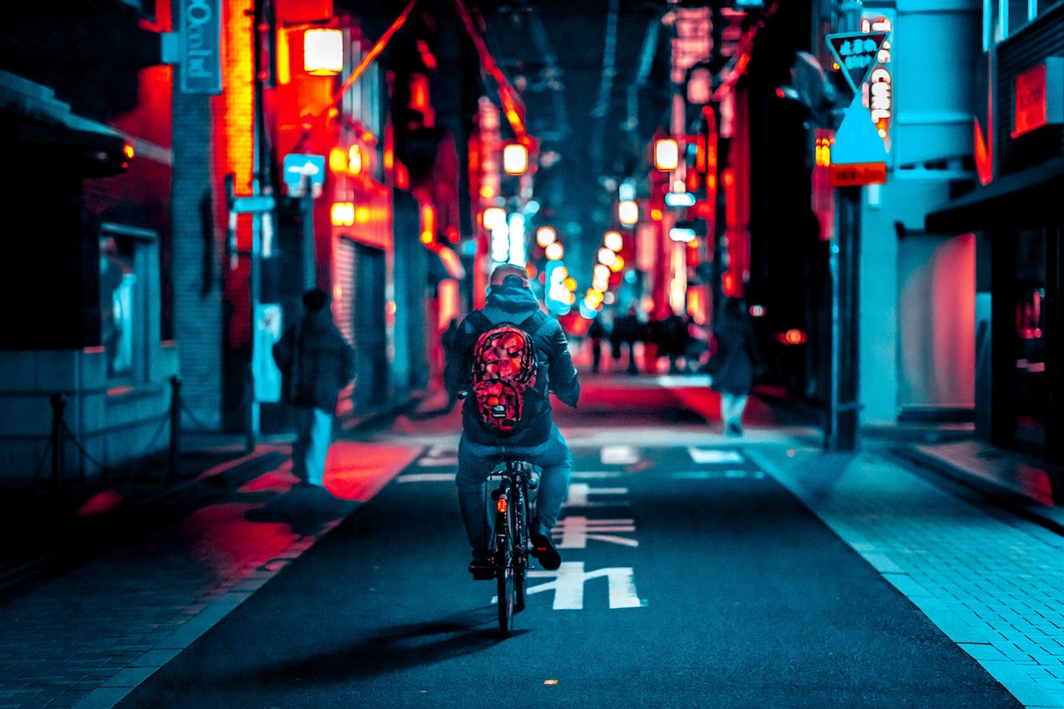 Man Riding a Bike in Kyoto at Night