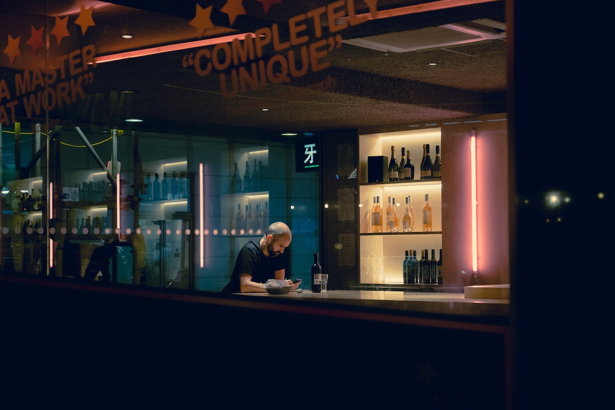 Man Sitting Alone at a Bar at Night