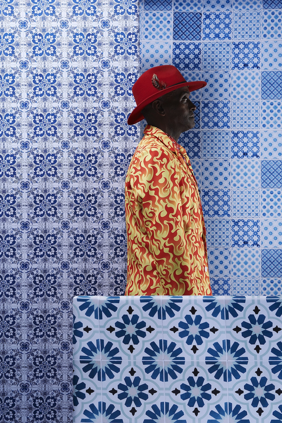 Man in Colorful Suit Against a Blue Tile Background