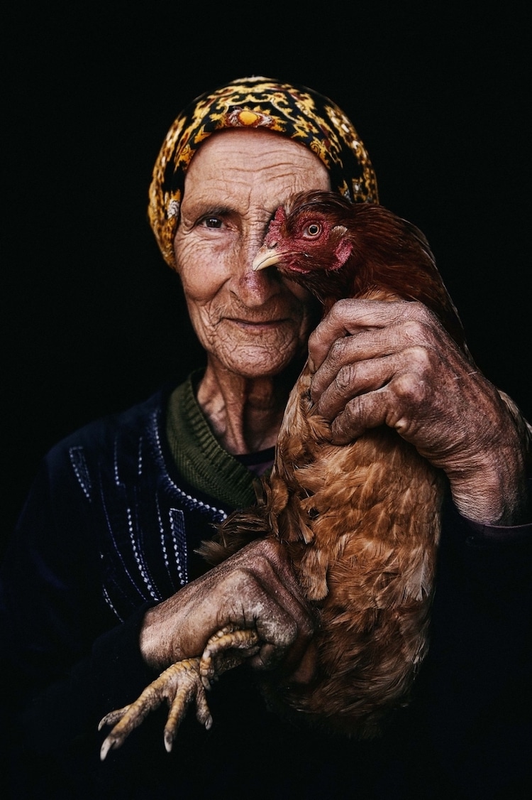 Elderly Woman Holding Up Her Hen