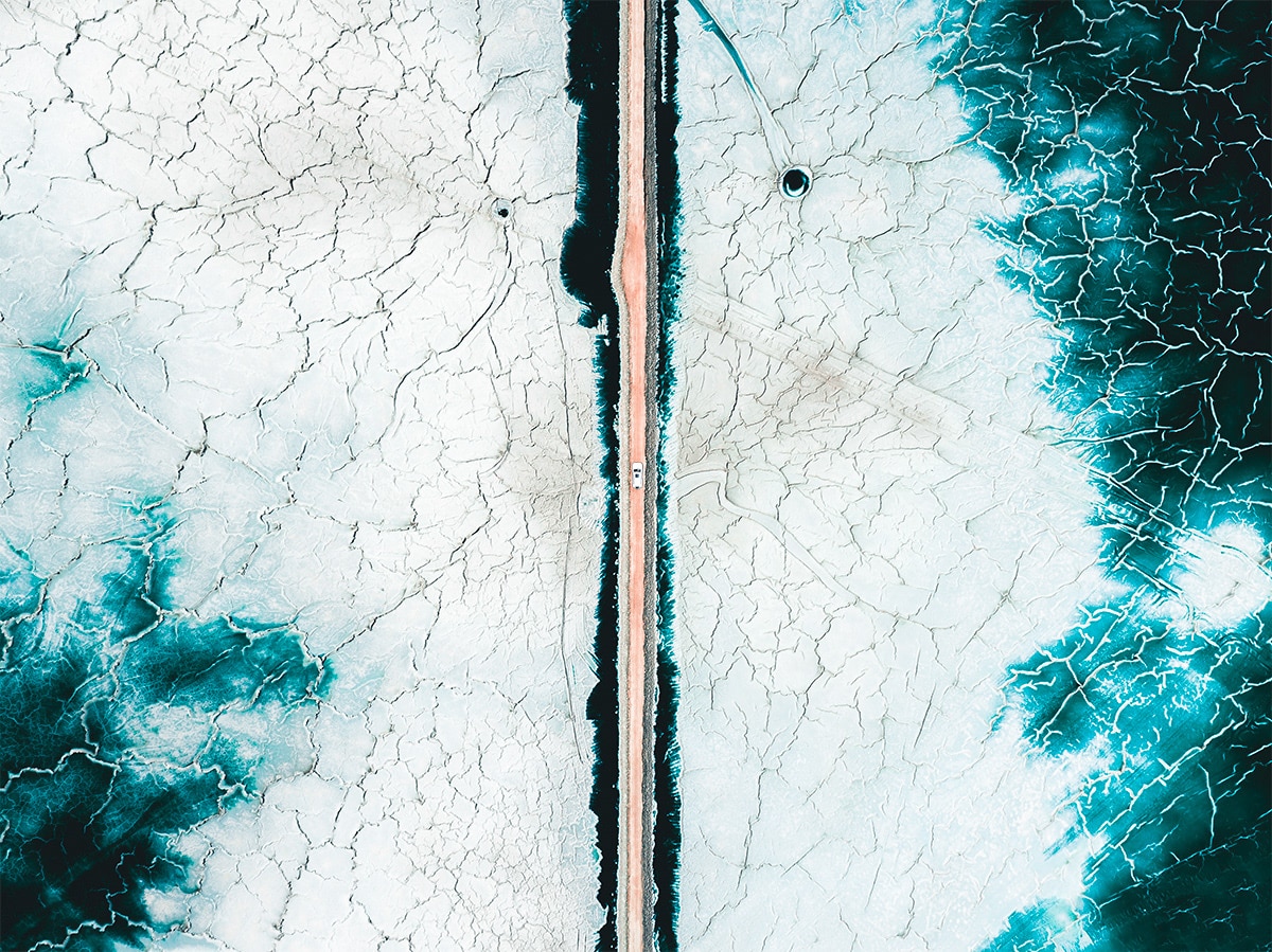 Aerial Photo of Road Cutting Through Icy Landscape