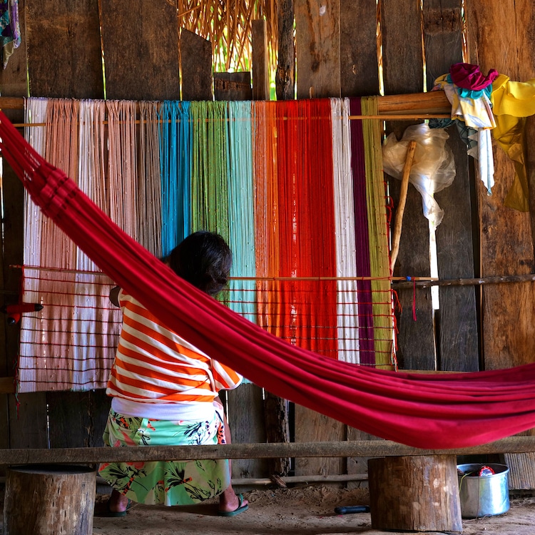 Guajajara woman in Brazil weaving a maniá hammock