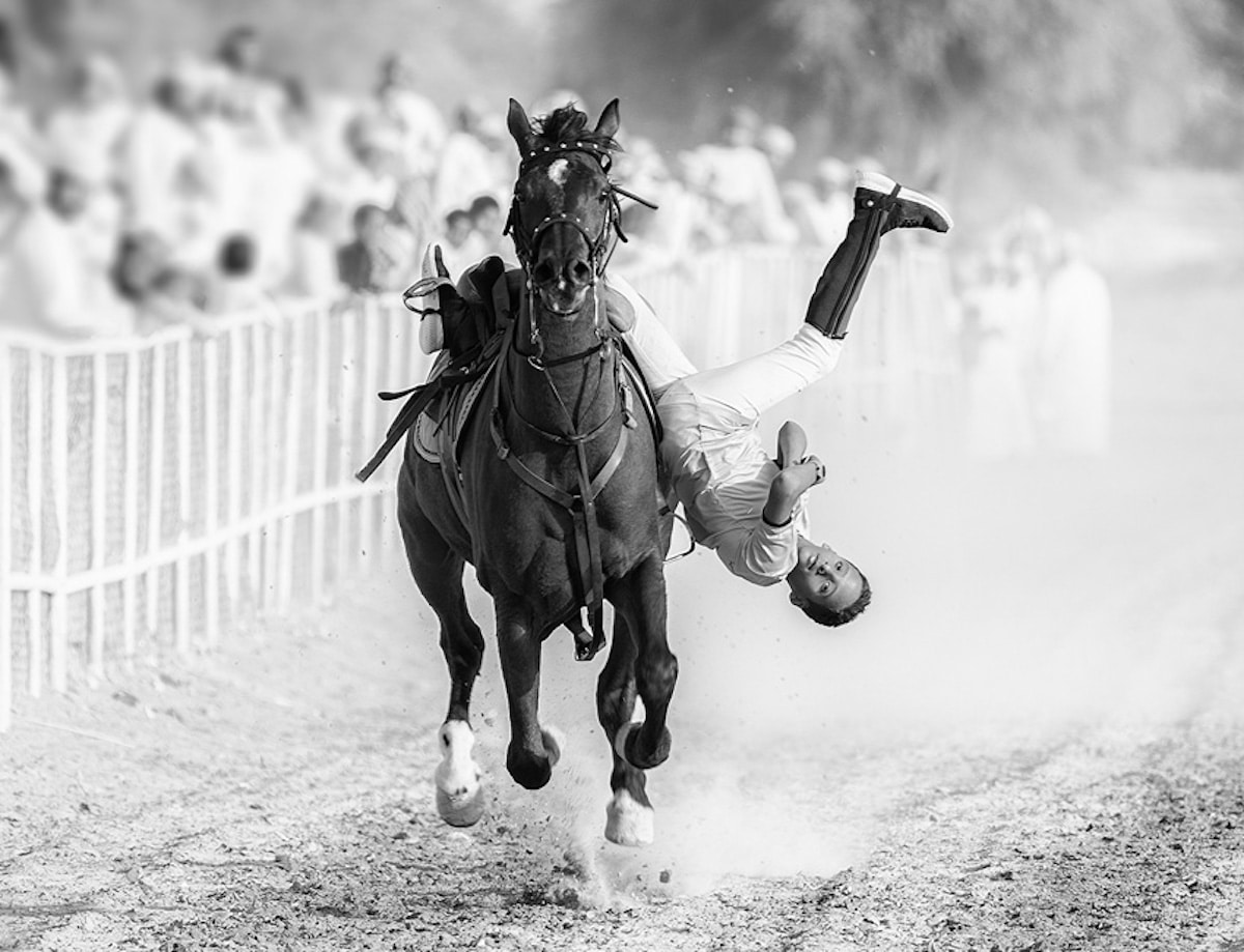 Young Man Tumbling Off a Horse During a Competition in the Sultanate of Oman