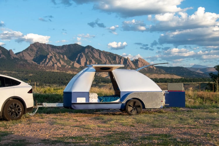 Colorado Teardrop trailer, attached to an EV, in front of a rocky landscape