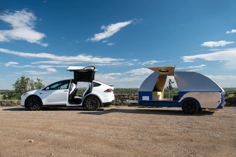 Colorado Teardrop trailer, attached to an EV, in front of a rocky landscape