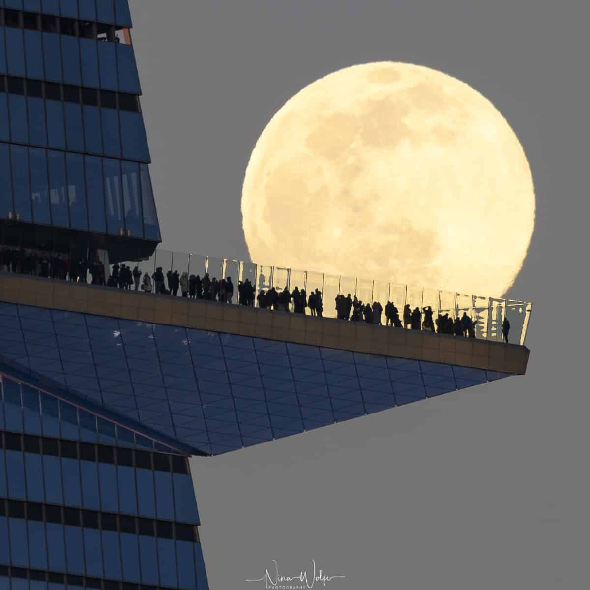 Full Moon Behind Balcony Full of People