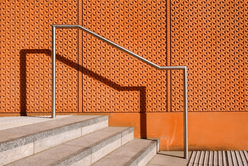 Metal Handrail in Front of a Terracotta Building