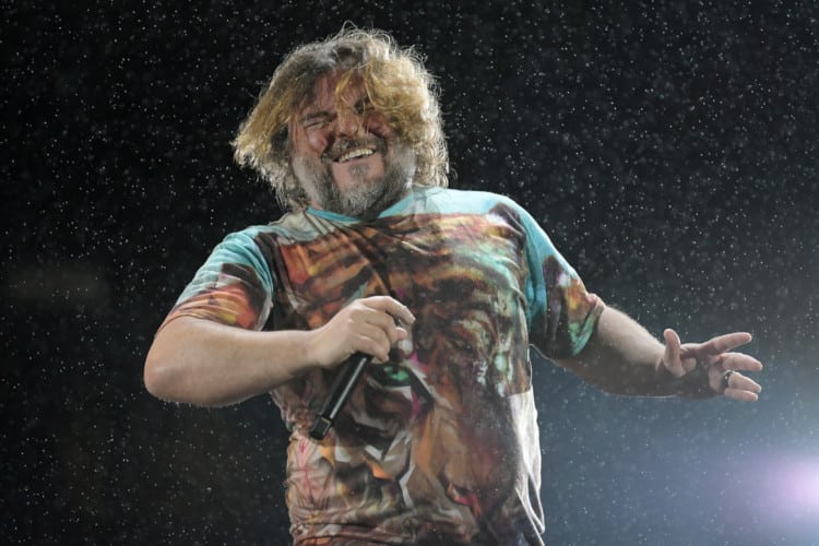 Jack Black performing and holding a microphone