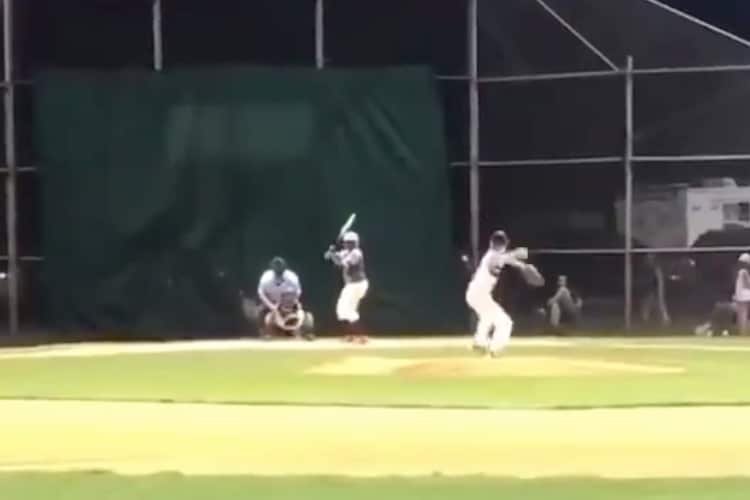 Boy is seen at bat from afar, before scoring a home run