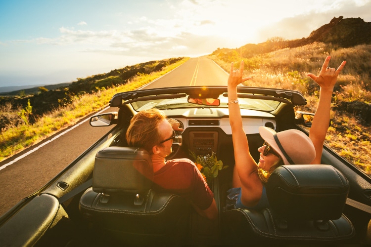 Happy Couple drives a convertible on a road trip