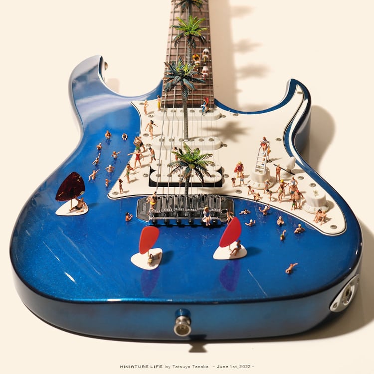 a blue guitar doubles as a pool for miniature people