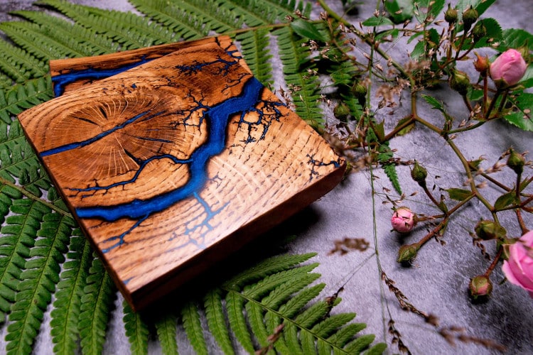 wood coaster decorated with Lichtenberg Figure and blue paint to emulate a river