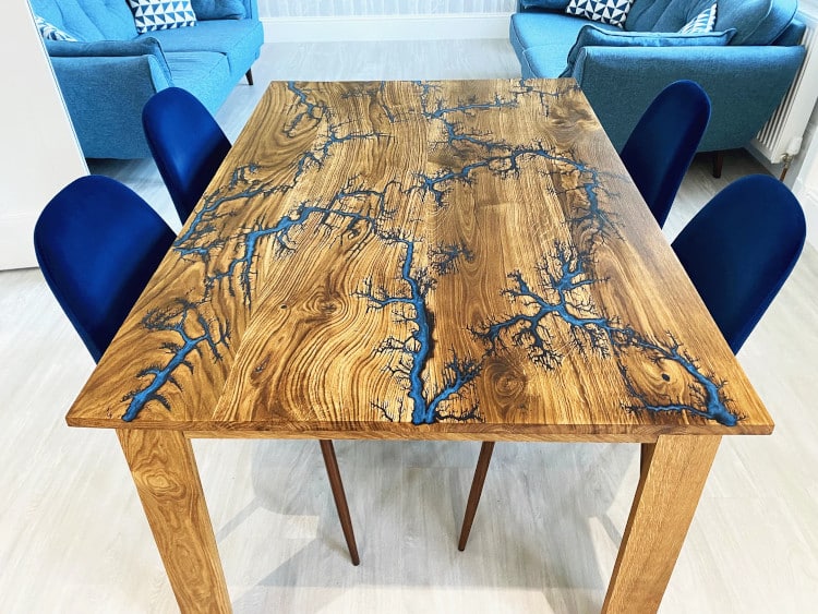 wood table decorated with Lichtenberg Figure and blue paint to emulate a river