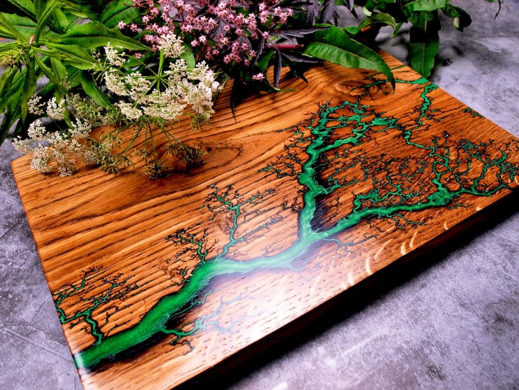 wood coaster decorated with Lichtenberg Figure and green paint to emulate a river