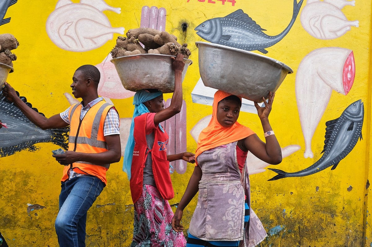 Women carrying baskets on their head at market in Ghana