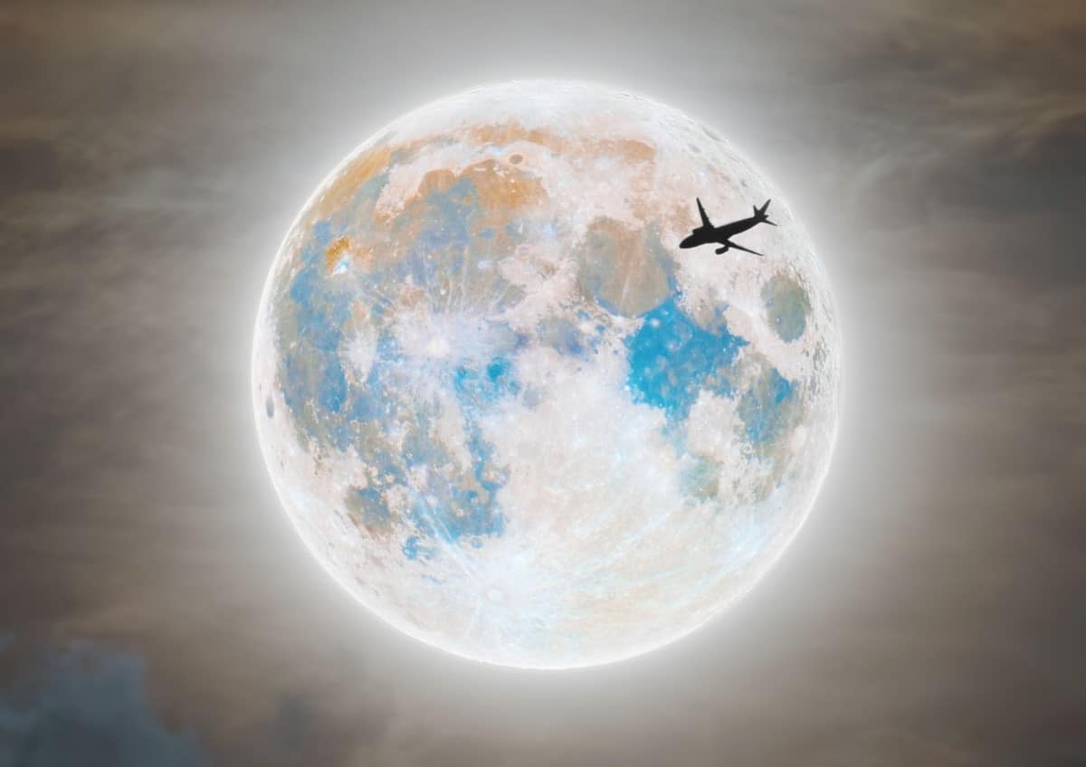 Airplane Passing in Front of Blue Supermoon by Andrew McCarthy