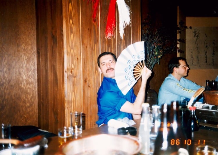 Personal photo of Freddie Mercury playfully holding a folding fan in a Japanese restaurant after a concert.