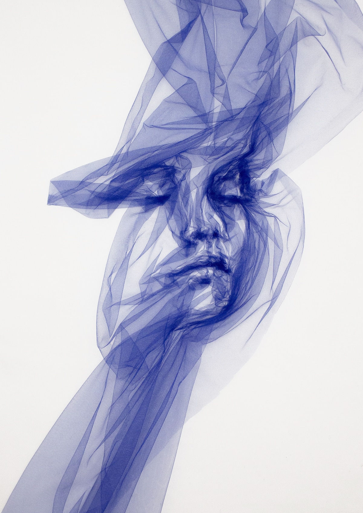 An example of Art Materialism - a face emerging from a single piece of tulle by artist Benjamin Shine