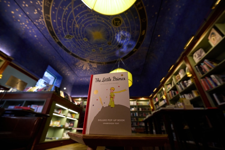 The little prince book in the foreground with bookstore in the background
