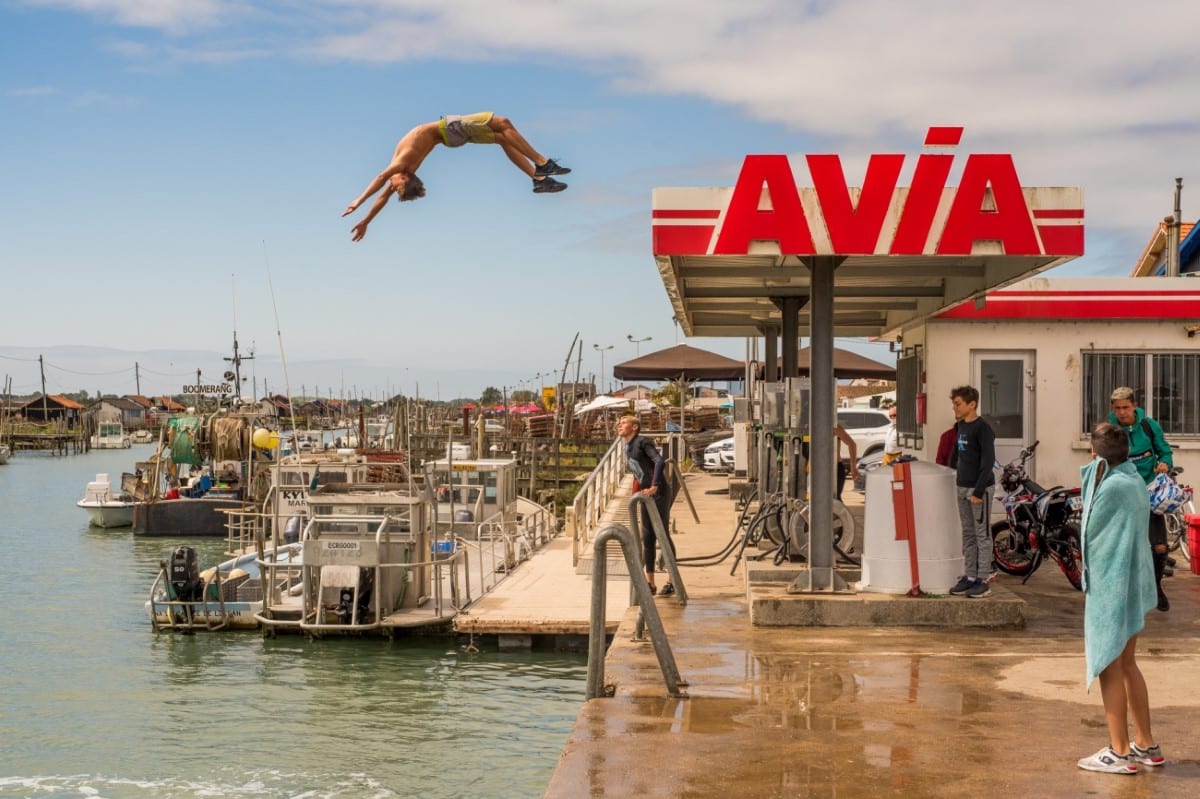 Boy jumping into the water at a seaside resort in France