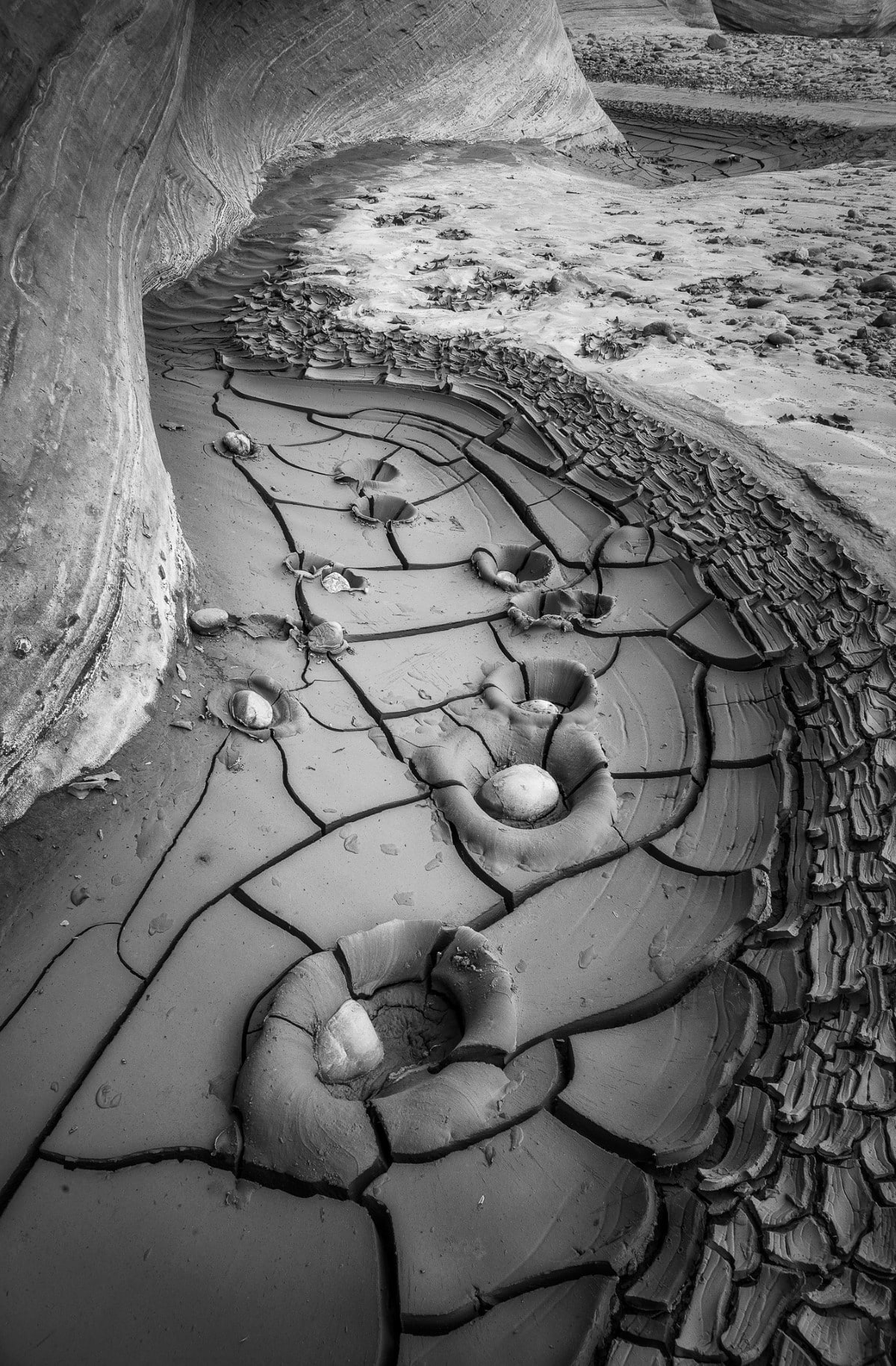 Black and white photo of dry river bed with cracked mud