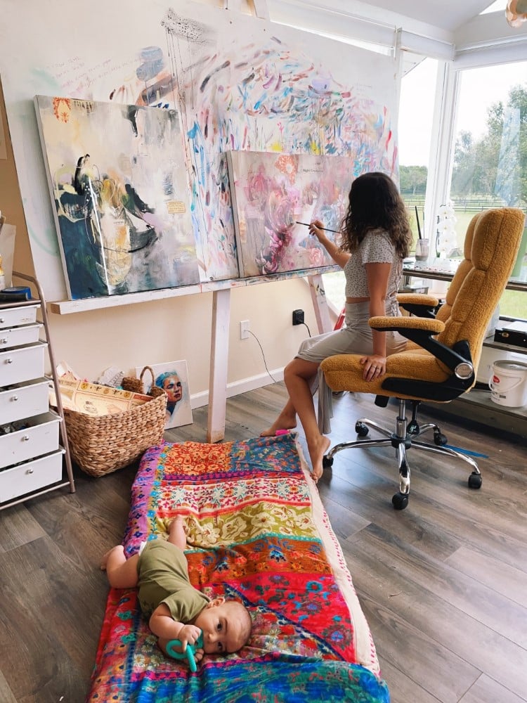 Artist Dimitra Milan Painting in Her Studio while Her Baby Plays