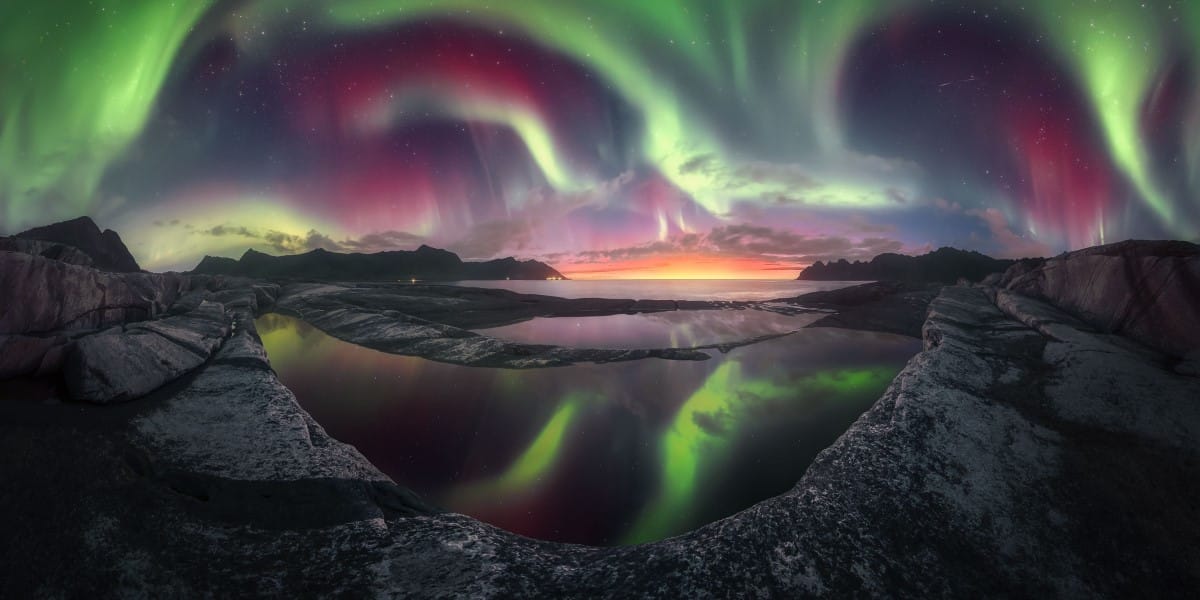 A 300° panorama captured on Senja Island (Norway) featuring the setting sun and an intense kp7 Northern Lights display