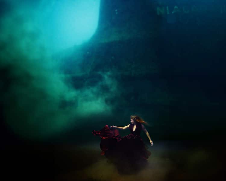 woman underwater in maroon dress for for the deepest underwater portrait shoot