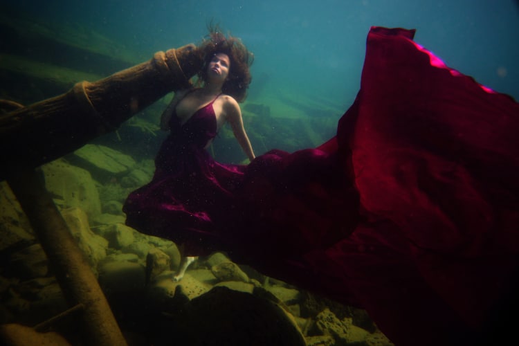 woman underwater in maroon dress for for the deepest underwater portrait shoot