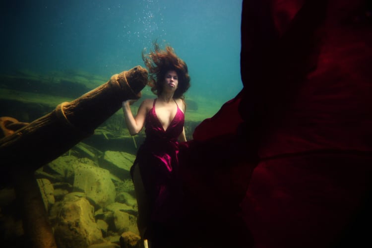 woman underwater in maroon dress for for the deepest underwater portrait shoot