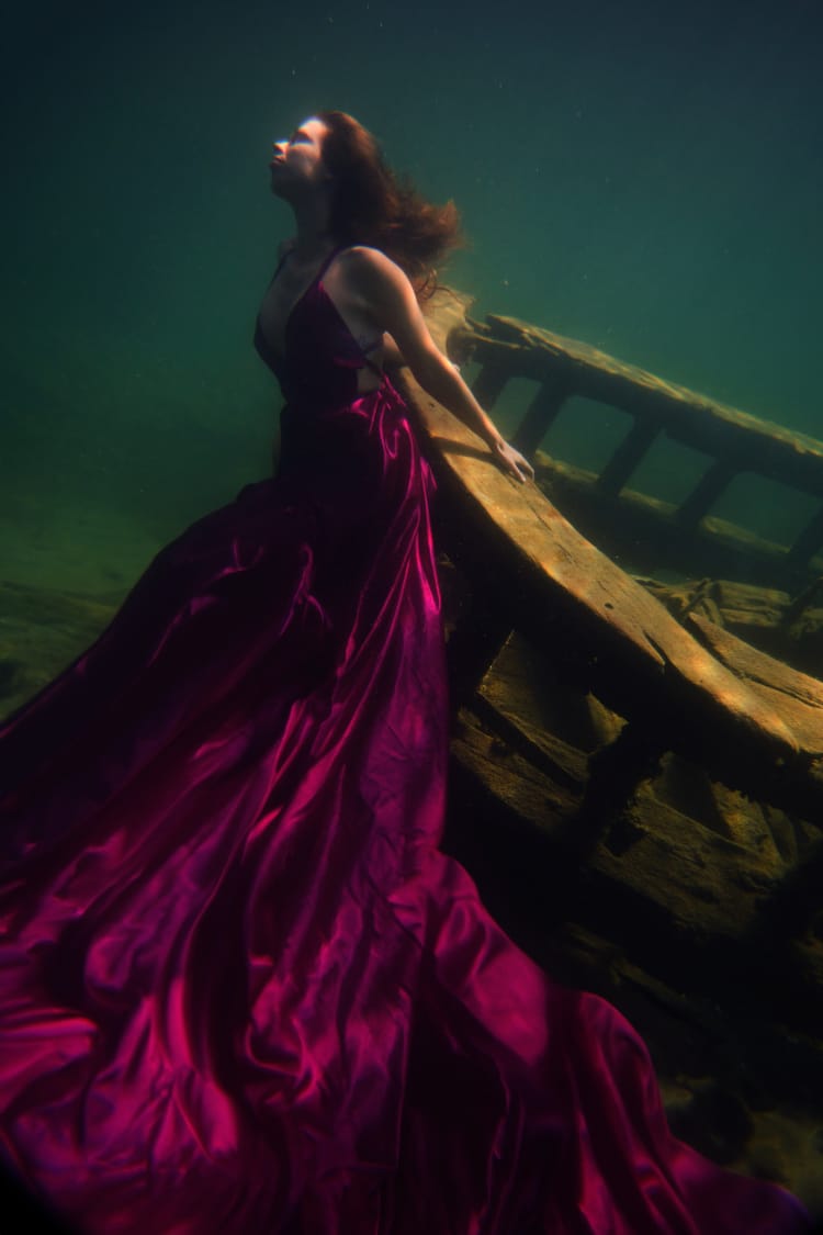 woman underwater in maroon dress for for the deepest underwater portrait shoot