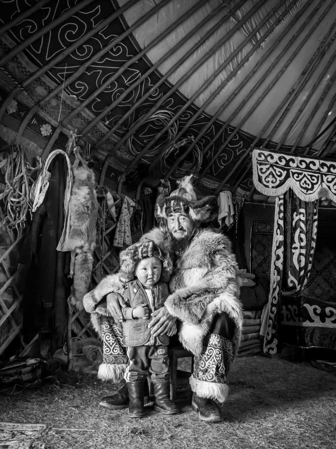 Black and white Mongolian eagle hunter and his son