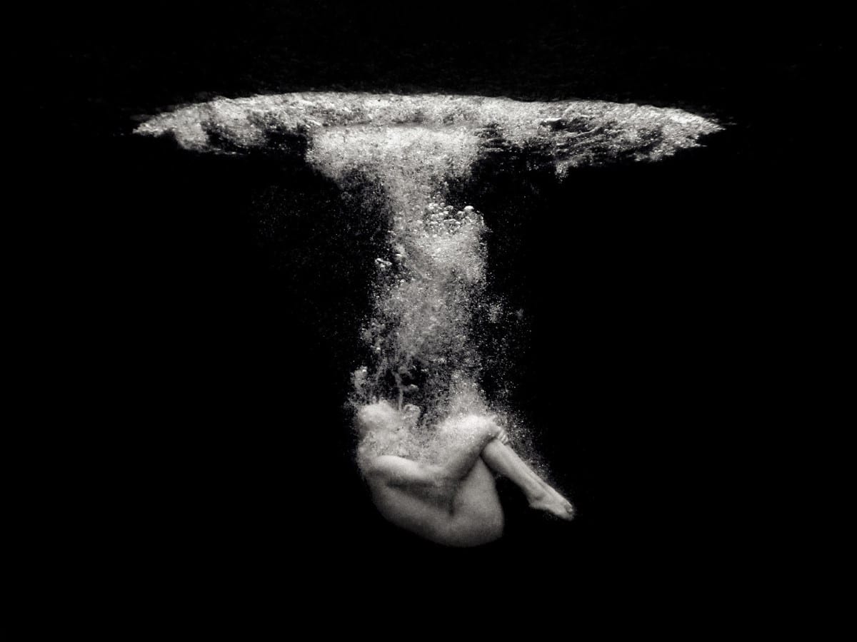 Artistic black and white photo of a person under water