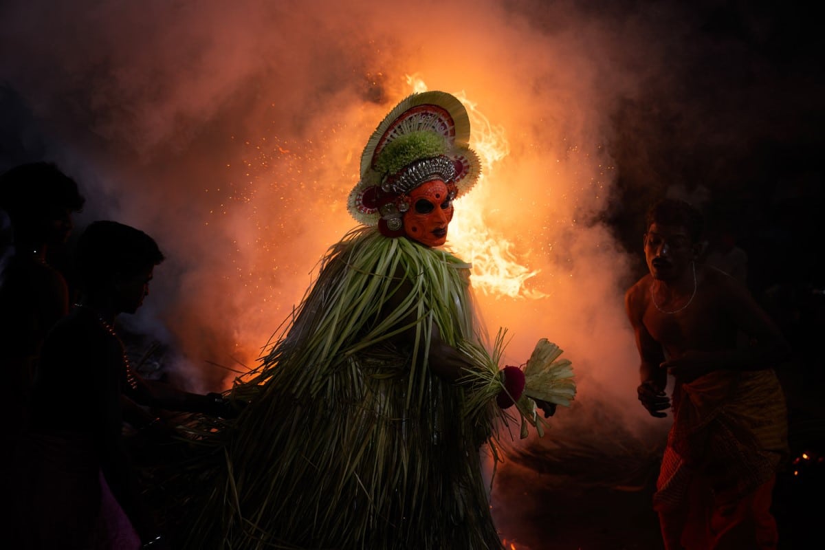Gulikan Theyyam (or Guliga Theyyam) in front of a bonfire