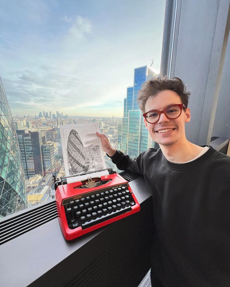 James Cook Holds Up Typewriter Drawing Of London Skyline