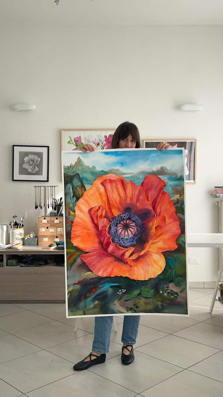 Janet Pulcho Holding Up Portrait of Orange and Blue Flower