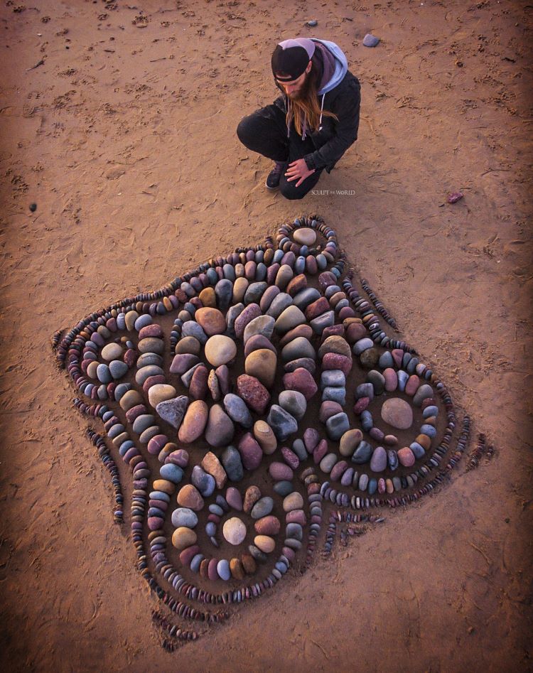 Jon Foreman Kneels Next To Square Spiral Multi-colored Rock Design On Beach