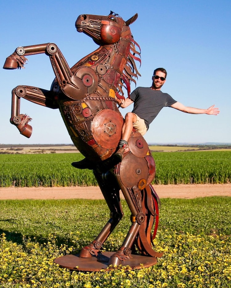 Sculptor Jordan Sprigg sitting atop his life-size metal horse sculpture