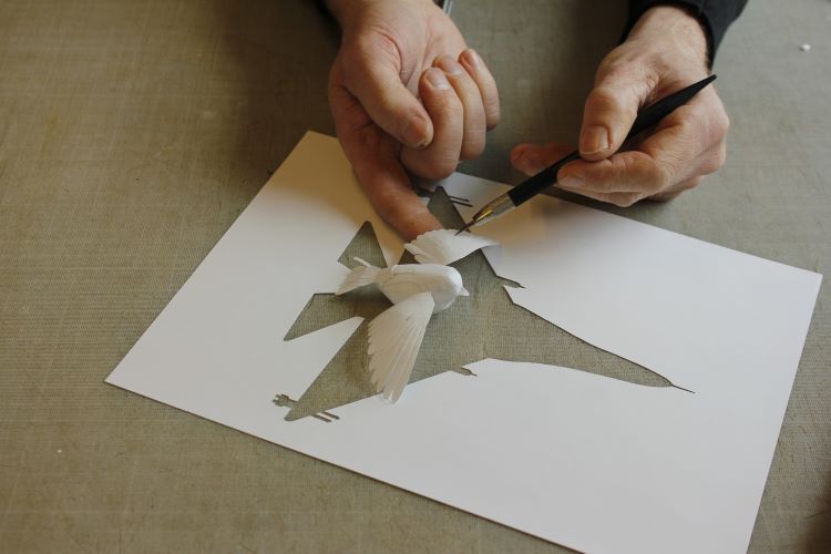 Peter Callesen Paper Sculpture Of Songbird In Flight Over Cutout Of Fighter Jet