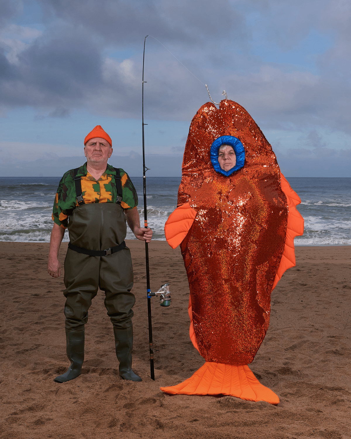 Couple dressed up as a fishman and goldfish on a beach in Portugal