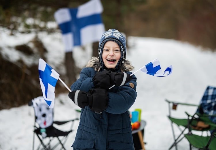 Finnish boy with Finland flags on a nice winter day. Nordic Scandinavian people.