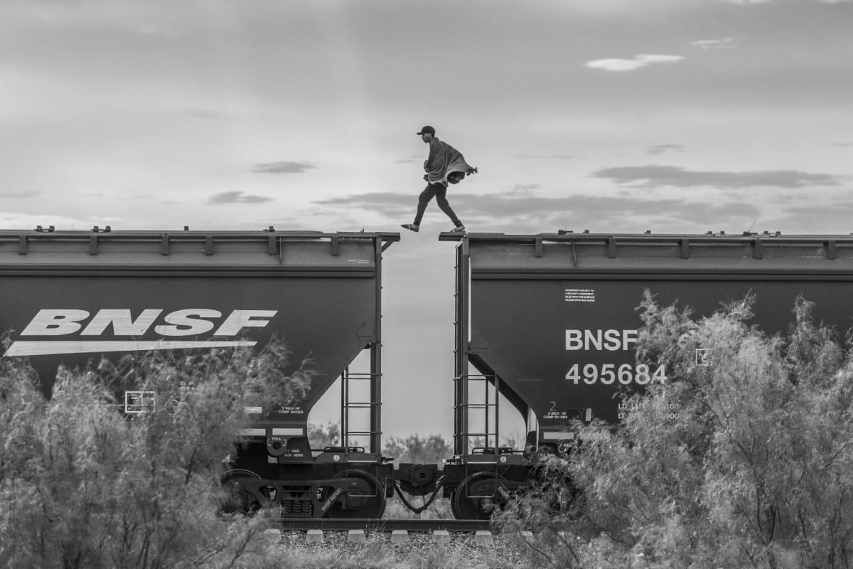 A migrant walks atop a freight train known as “The Beast.” 