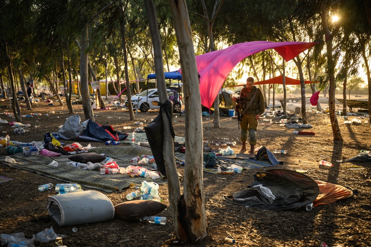 An Israeli security forces officer searches the site of the Supernova music festival for personal effects of victims of the 7 October Hamas attack, which resulted in around 1,200 deaths, more than 2,500 reported injuries, and some 250 people held hostage from the festival and communities near the Gaza border.