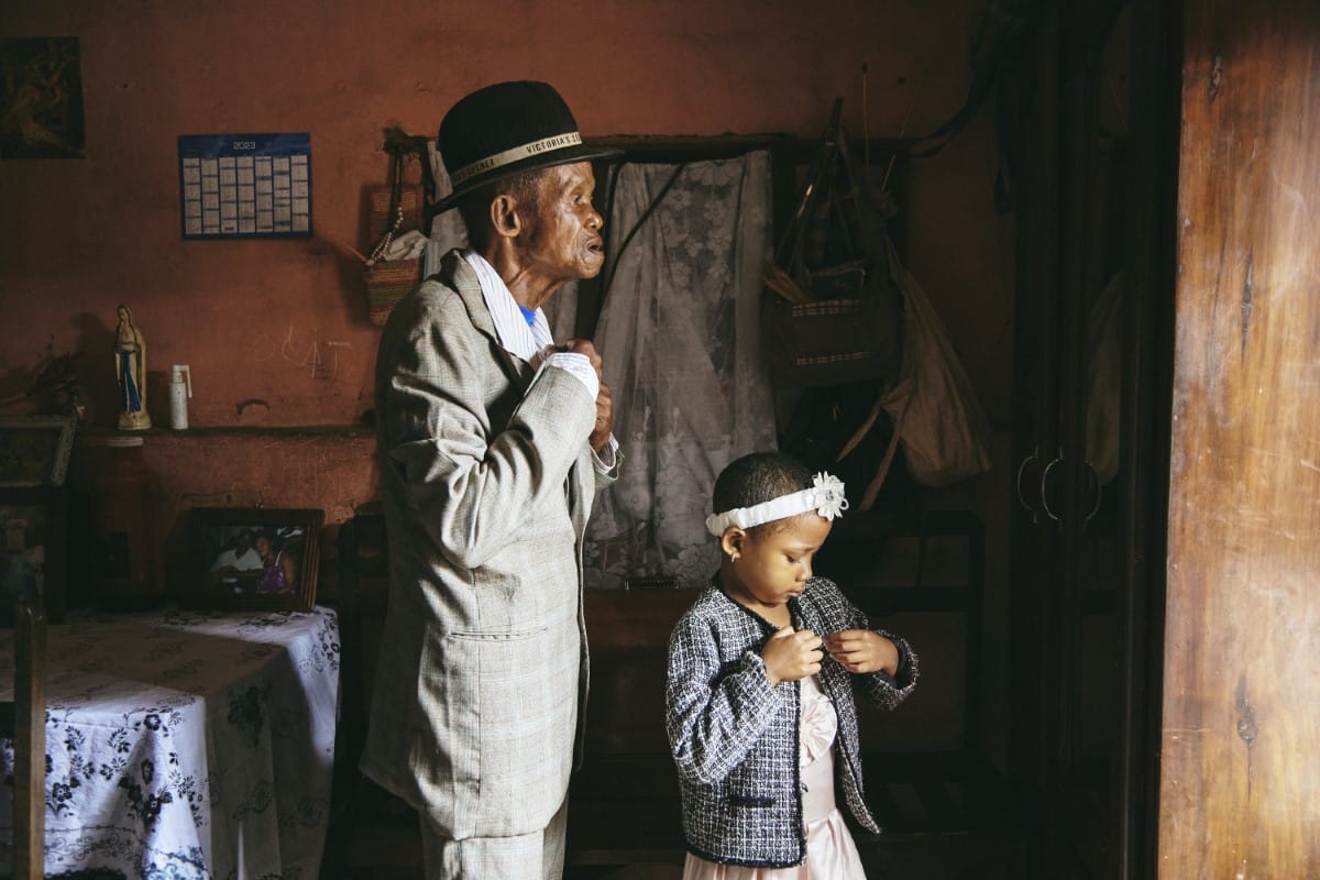 Girl and her grandfather getting ready for church in Madagascar