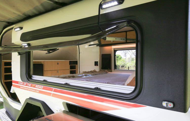 Photo From The Outside Of A Camper Showing The Inside Bed