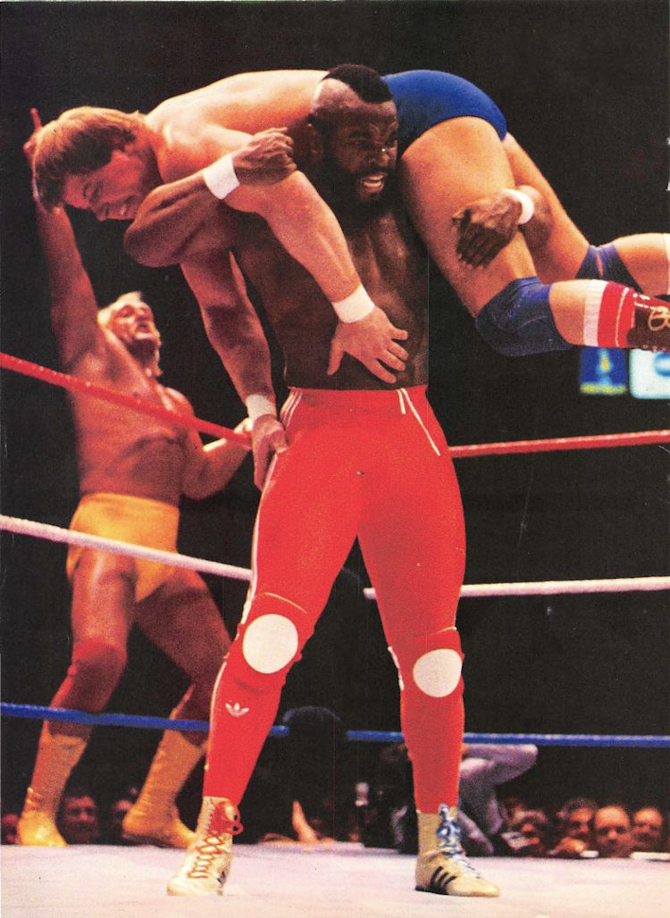 Mr T. hoists "Rowdy" Roddy Piper up onto his shoulders as Hulk Hogan cheers in the background during the main event of Wrestlemania, March 1985